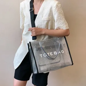 Chic silver transparent mesh tote bag with bold TOTE BAG lettering and black straps