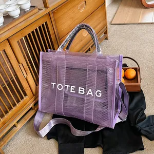 Minimalist purple mesh tote bag with white text print on a rustic wooden background