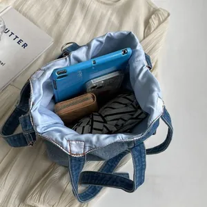 Blue denim tote bucket bag with large capacity showing internal storage and lining