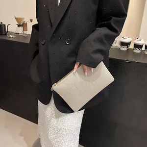 Détail d'une pochette à paillettes champagne doré avec fermeture éclair pour soirée ou maquillage