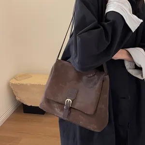 Vintage dark brown crossbody bag with matte leather finish and flap metal buckle style
