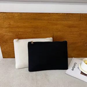Détail de pochettes en toile minimalistes noir et beige avec fermetures éclair dorées