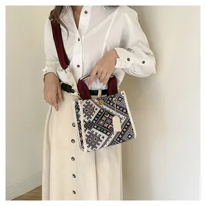 Detail of ethnic geometric tapestry tote with leather trim and gold swivel lock