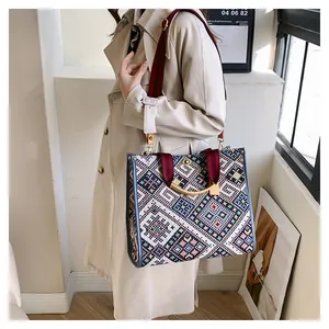 Detailed shot of ethnic woven tote bag with colorful geometric patterns and gold handle