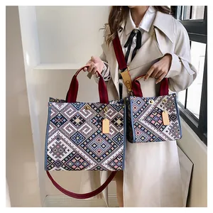 Ethnic style woven canvas tote bags with blue trim and metal twist locks on a model