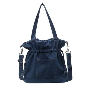 Pleated denim drawstring handbag with front pocket and adjustable crossbody strap
