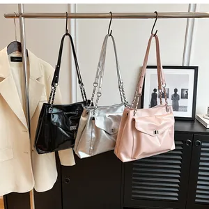Detailed view of large tote bags in black, silver, and pink glossy finish with chain straps