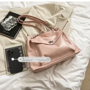 Size comparison of the pink glossy chain tote bag with a smartphone for scale