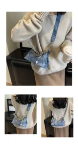 Detail view of denim patchwork shoulder bag with silver chain and blue strap