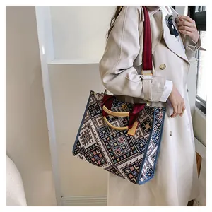 Close-up of ethnic woven tote bag featuring geometric patterns and resin handles