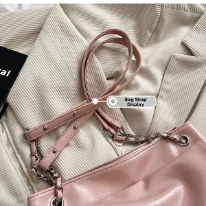 Detail of pink patent leather shoulder strap with silver rivets and metallic chain