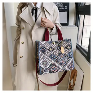 Detailed close-up of ethnic geometric tapestry tote bag with leather trim and shoulder strap