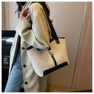 Detail of canvas tote with black leather trim and metal clasp for daily use