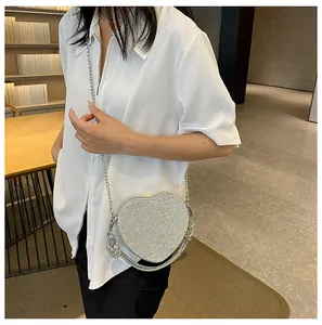 Borsa a spalla a cuore in strass argento con catena in metallo su una modella