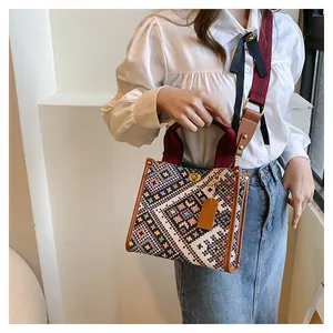 Detailed macro view of ethnic patterned fabric tote with golden twist lock and leather trim