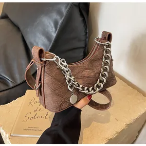 Detail of vintage brown denim shoulder bag featuring silver chain and letter patterns