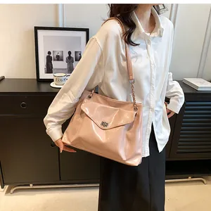 Detail of pink patent leather tote bag with silver twist lock and chain strap