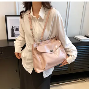 Detail of pink patent leather tote bag with silver chain strap and metallic clasp