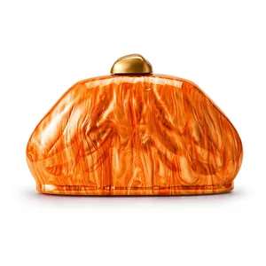 Detailed macro view of acrylic evening clutch with amber marble pattern and gold buckle