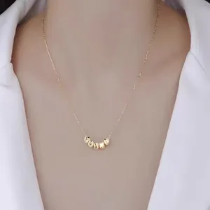 Detail of five golden lucky beads on a delicate S925 sterling silver necklace for women
