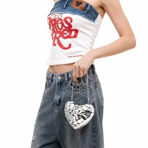 Chic silver heart-shaped metallic chain bag paired with stylish denim outfit