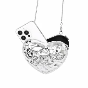 Silver heart-shaped metallic clutch bag with fluid ripple texture and silver chain strap