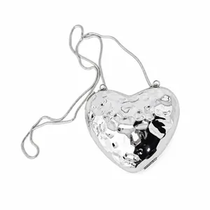 Silver heart-shaped evening clutch bag with hammered metal texture and snake chain strap