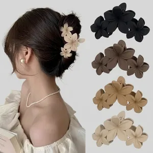Detailansicht der Acetat-Haarklammern mit drei Blumen in Schwarz, Braun und Beige