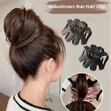 Close-up detail of matte black and grey hair claw clips for creating a messy bun hairstyle