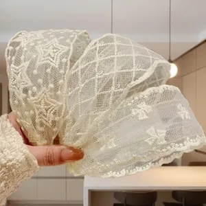 Detailansicht von cremefarbenen Spitzen-Stirnbändern mit Sternen- und Stickmustern