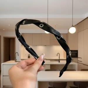 Nahaufnahme des schwarzen Leder-Haarreifs mit Knotendetail und silbernen Metallösen