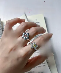 Detailed view of S925 silver flower rings with vibrant zircon inlay and fine texture