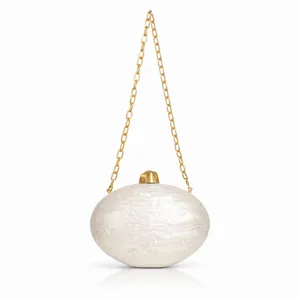 Detailed macro of creamy marble acrylic clutch with gold clasp and elegant chain