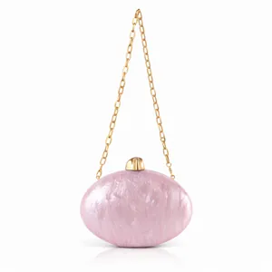 Detail of pink marbled acrylic evening bag with metallic gold clasp and chain strap