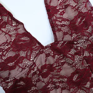 Detailed macro view of burgundy floral lace fabric with semi-sheer hollow out texture