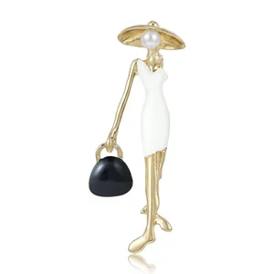 Eleganter Modedame-Brosche mit Goldfinish, weißem Emaille-Kleid und Perlendetail