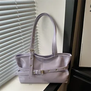 Detail of lavender faux leather tote featuring gold buckle and adjustable eyelet strap