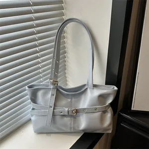 Detail shot of light blue leather shoulder bag with buckle and metal eyelet accents