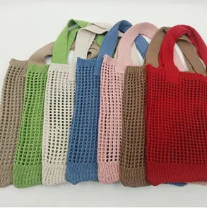 Dettaglio di borse tote in maglia colorata con trama a rete e manici larghi