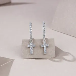 Macro shot of S925 silver cross drop earrings with sparkling pavé moissanite stones