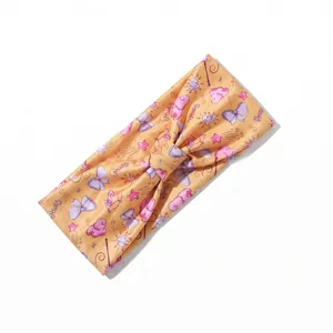 Detail of a yellow stretch headband with pink clouds, stars and knots for fitness