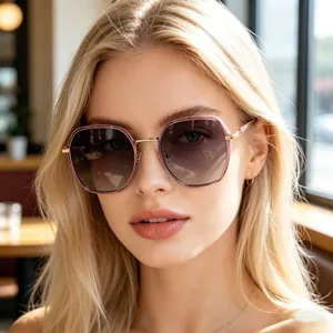 Close-up of stylish gradient lens sunglasses with gold metal temples on a female model