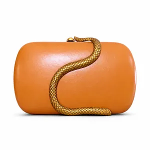 Macro view of the luxury snake-shaped gold clasp on an amber faux leather clutch