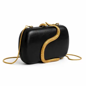 Detail of elegant black clutch bag with golden snake buckle and metallic chain strap