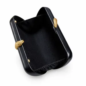 Internal view of black hard shell evening clutch bag with gold snake-shaped hardware