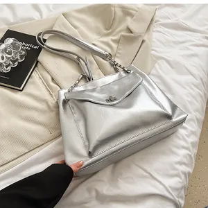 Close-up of metallic silver tote bag featuring crinkled texture and sleek metal twist lock