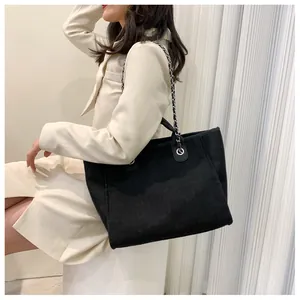 Détail du grand cabas en toile noire avec bandoulière en chaîne argentée et cuir