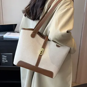 Canvas contrast tote bag with leather trim and gold twist lock in an office setting