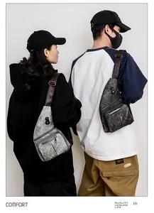 Détail de sacs de poitrine en cuir souple gris avec bandoulières réglables et zips