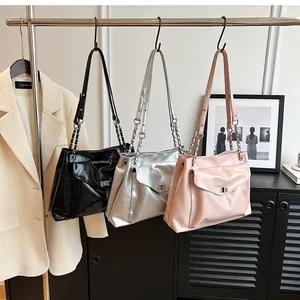 Three shiny wrinkled leather shoulder bags in black silver and pink on a hanger